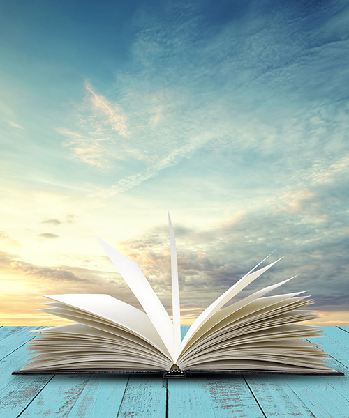 Open book on table with evening sky background